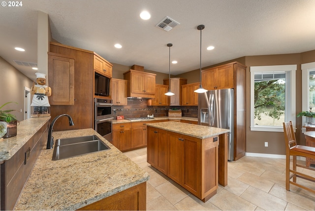 kitchen with light stone counters, pendant lighting, sink, tasteful backsplash, and stainless steel appliances