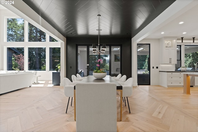 dining room with an inviting chandelier, wood ceiling, and light parquet flooring