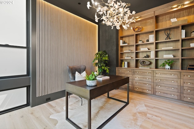 office space featuring light wood-type flooring, wooden walls, a chandelier, and built in features