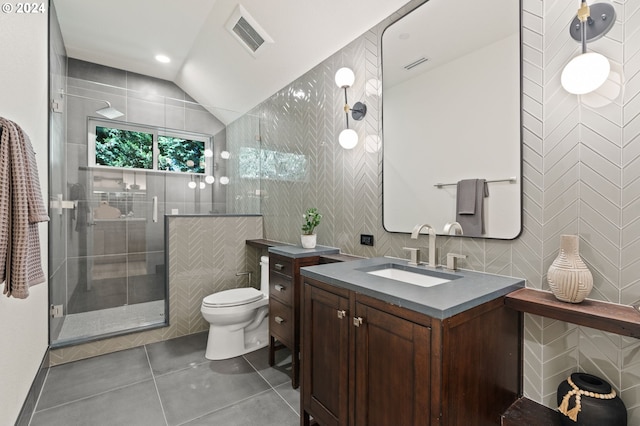 bathroom with tile walls, vanity, lofted ceiling, toilet, and an enclosed shower