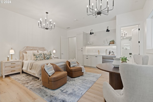 bedroom featuring light hardwood / wood-style flooring, a chandelier, and sink