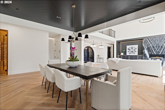 dining area with an inviting chandelier and light parquet flooring