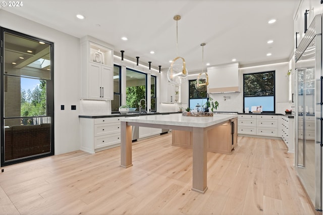 kitchen with a breakfast bar, decorative backsplash, white cabinetry, and pendant lighting