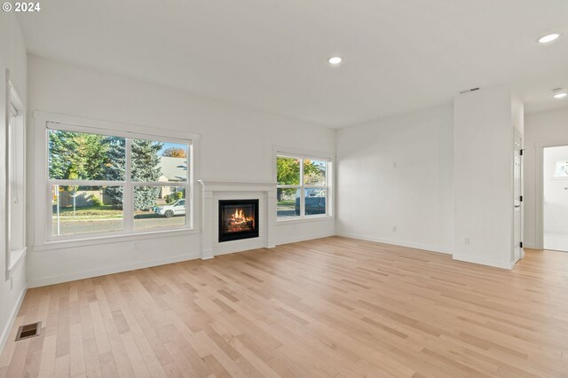 unfurnished living room with light hardwood / wood-style flooring and plenty of natural light