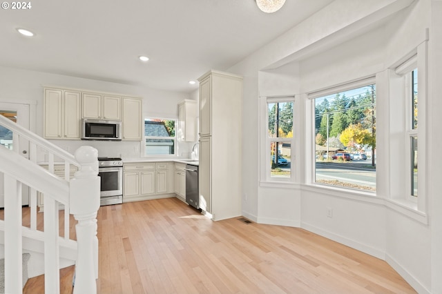 kitchen featuring stainless steel appliances, light hardwood / wood-style floors, plenty of natural light, and sink