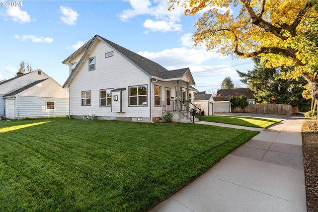 view of front of home with an outbuilding, a garage, and a front yard