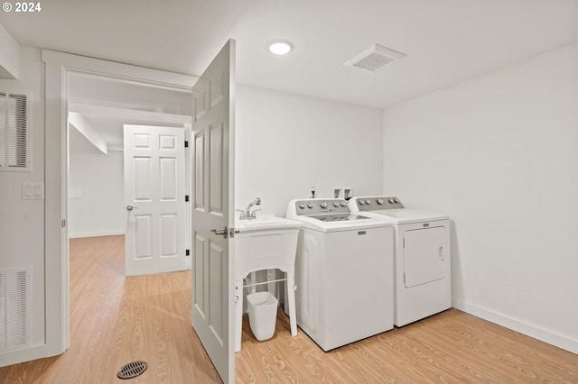 washroom featuring separate washer and dryer and light hardwood / wood-style flooring