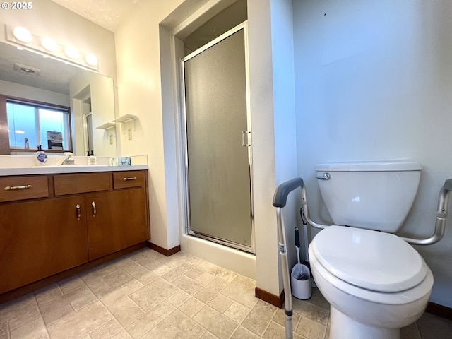 bathroom with vanity, a shower with shower door, and toilet