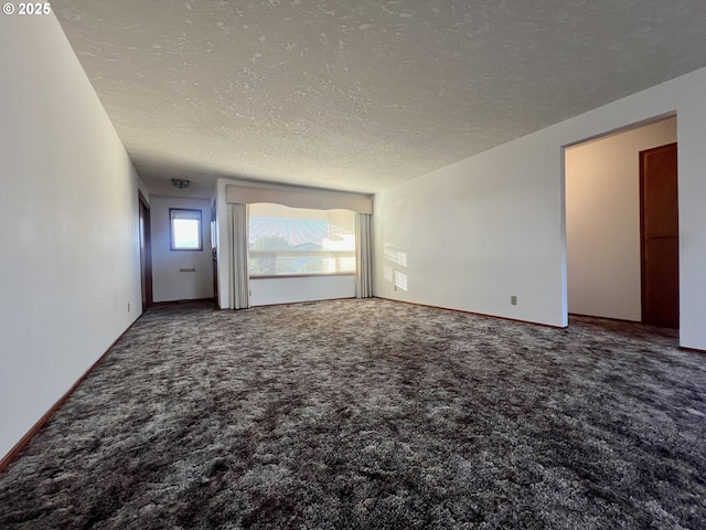 unfurnished living room with a textured ceiling and carpet flooring