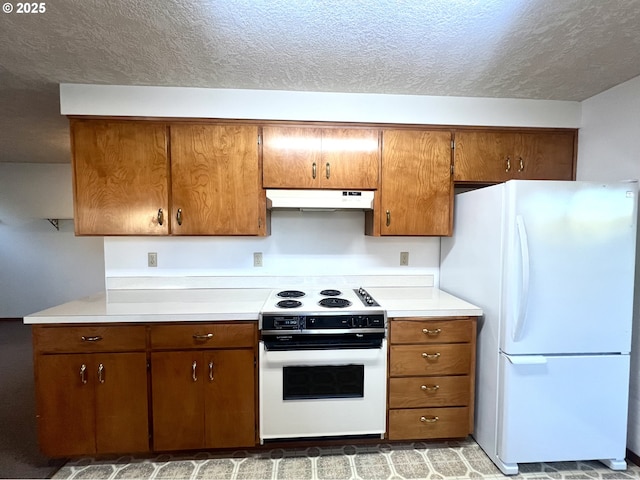 kitchen featuring a textured ceiling and white appliances