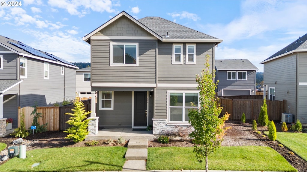 view of front of house with a front yard and cooling unit