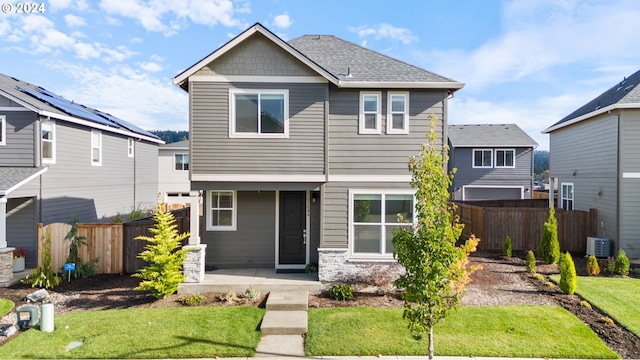 view of front of house with a front yard and cooling unit