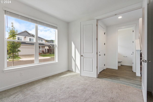 unfurnished bedroom featuring ensuite bathroom and carpet floors