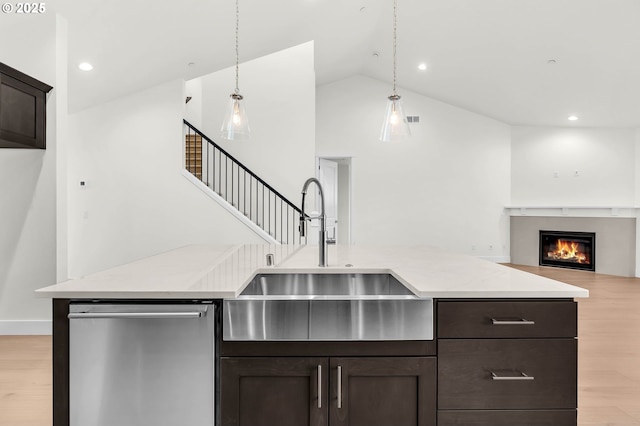 kitchen featuring sink, dark brown cabinets, dishwasher, pendant lighting, and light hardwood / wood-style floors