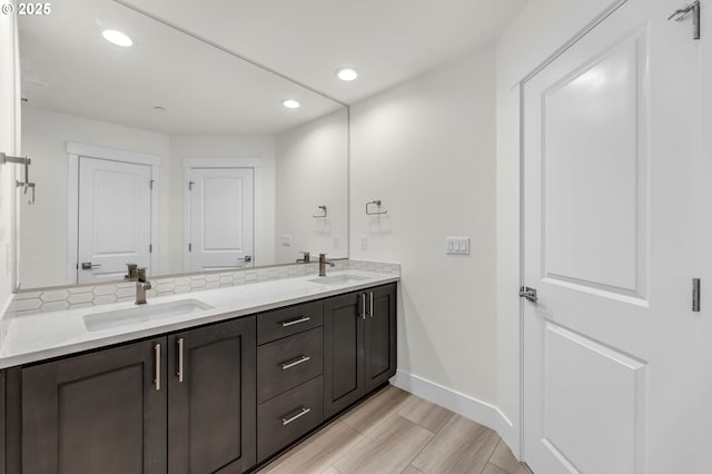 bathroom with vanity, hardwood / wood-style flooring, and tasteful backsplash