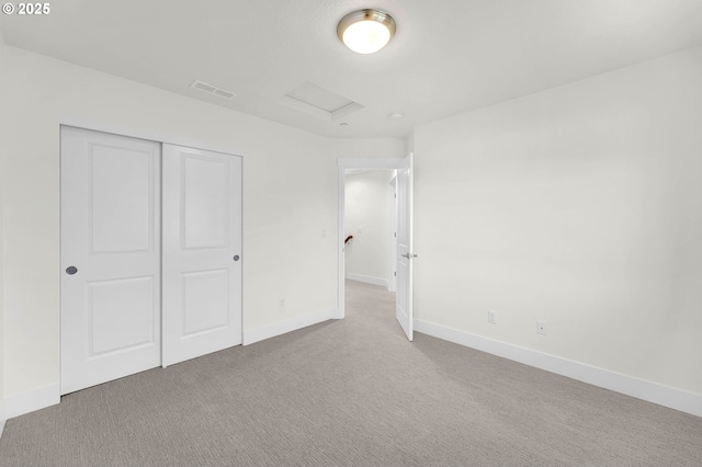 unfurnished bedroom featuring light carpet and a closet