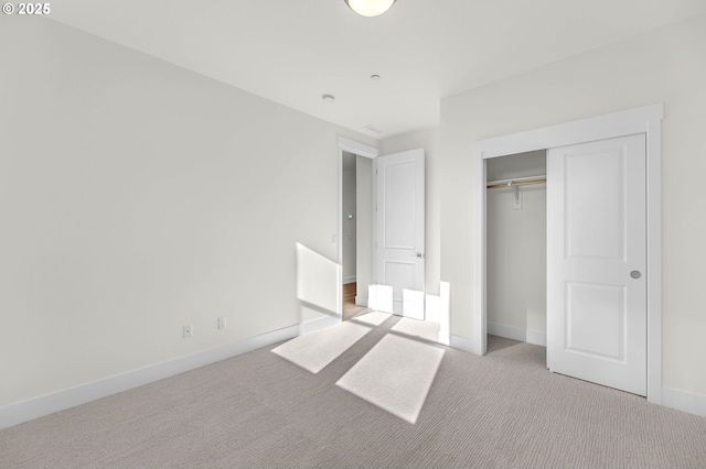 unfurnished bedroom with light carpet and a closet