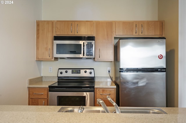 kitchen with light brown cabinetry, sink, and stainless steel appliances