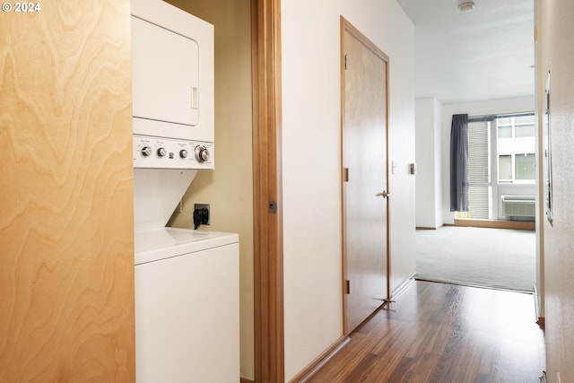 laundry room with a wall unit AC, dark hardwood / wood-style flooring, and stacked washer and clothes dryer