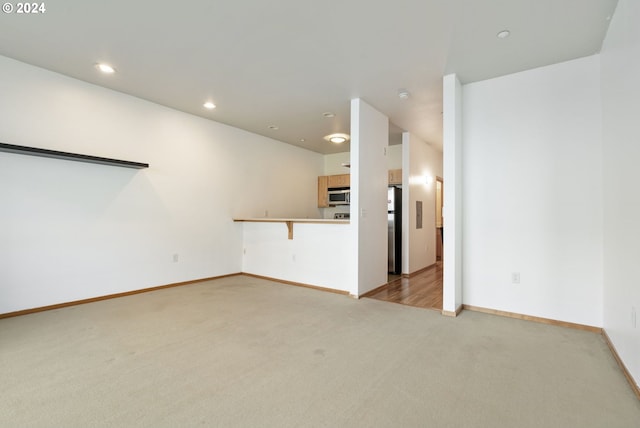 unfurnished living room featuring light carpet