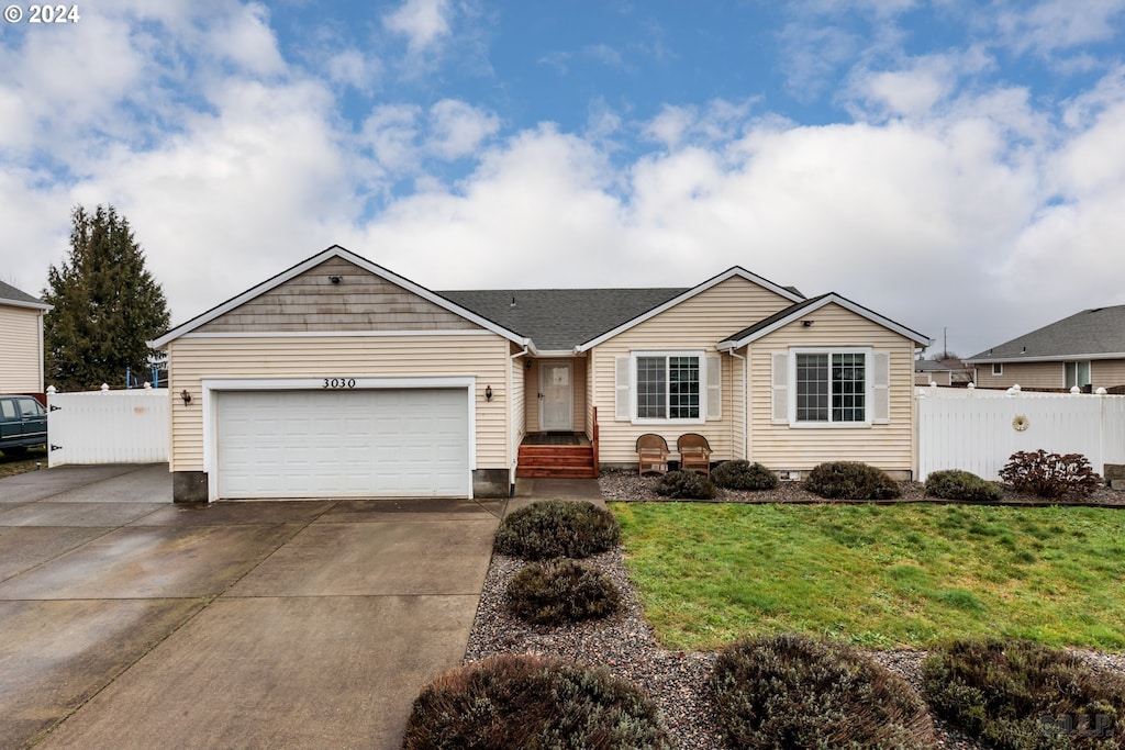 single story home with a garage and a front lawn