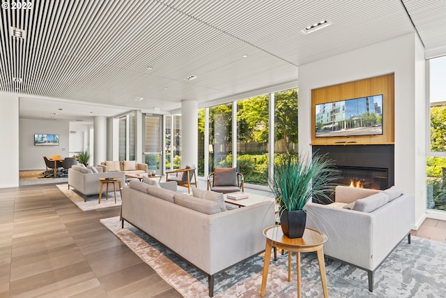 living room featuring floor to ceiling windows and a glass covered fireplace