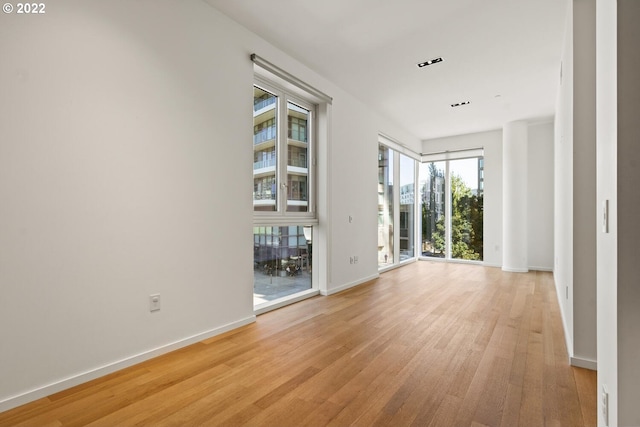 empty room featuring light wood-type flooring and baseboards