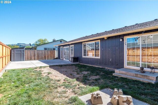 back of house with a lawn and a patio area