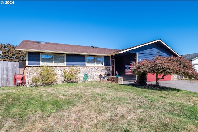 ranch-style house featuring a garage and a front lawn