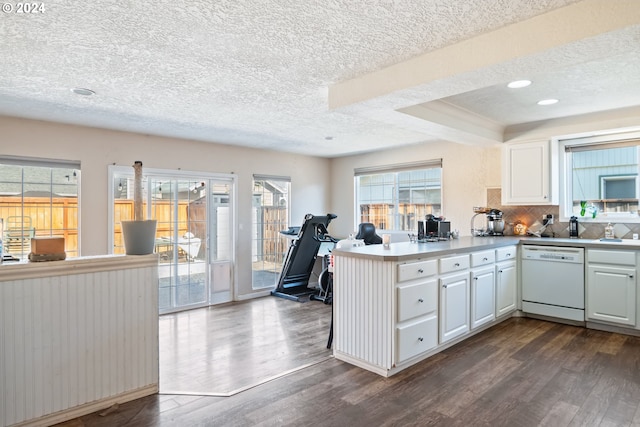 kitchen with kitchen peninsula, a textured ceiling, white dishwasher, dark hardwood / wood-style floors, and white cabinetry