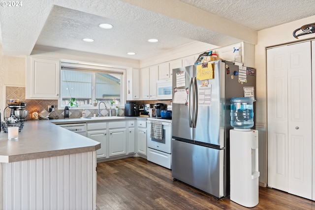 kitchen featuring white cabinets, sink, white appliances, and dark wood-type flooring