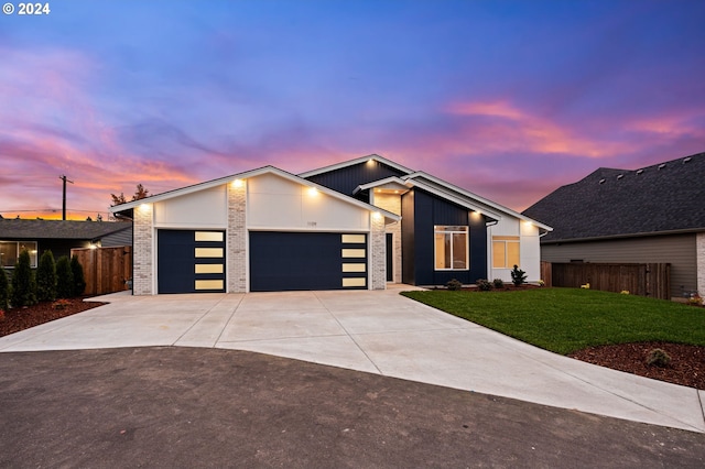 view of front of property with a garage, brick siding, fence, concrete driveway, and a front yard