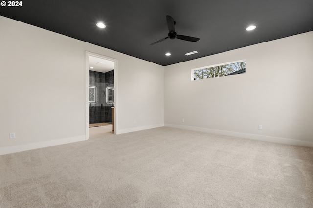 carpeted spare room with ceiling fan