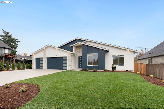 view of front of property featuring brick siding, an attached garage, a front yard, fence, and driveway