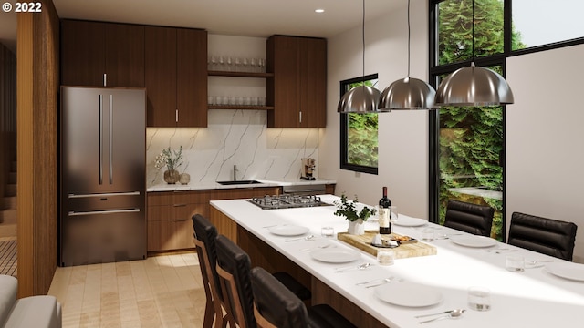 kitchen featuring appliances with stainless steel finishes, tasteful backsplash, decorative light fixtures, and sink