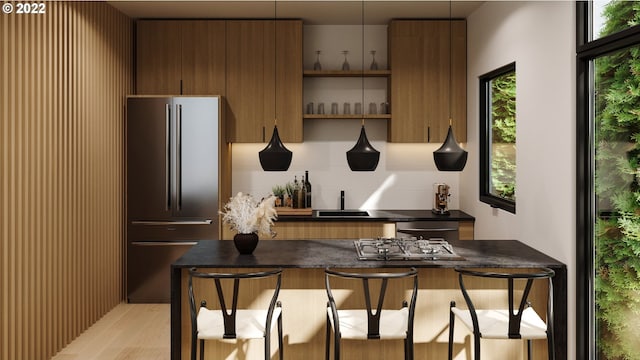 interior space featuring high quality fridge, light hardwood / wood-style floors, and decorative light fixtures