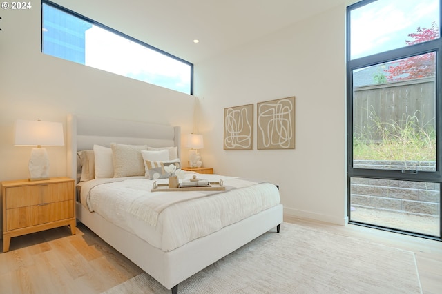 bedroom featuring hardwood / wood-style floors and a towering ceiling