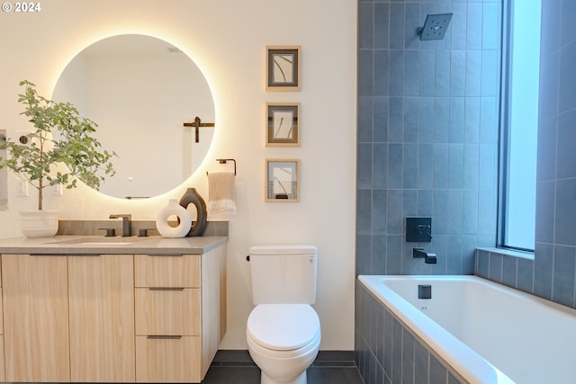 bathroom featuring tile patterned flooring, a relaxing tiled tub, toilet, and vanity