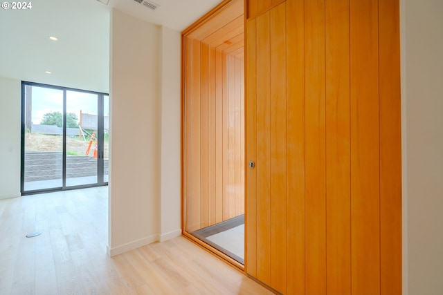 corridor with light hardwood / wood-style floors and a wall of windows