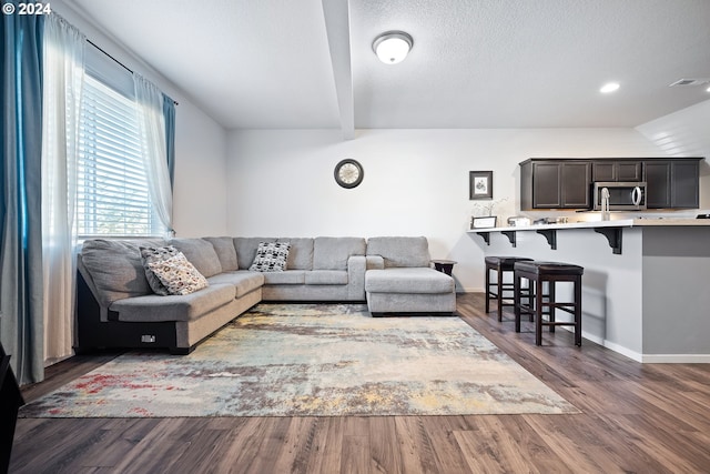 living room with a textured ceiling, vaulted ceiling, and dark hardwood / wood-style flooring