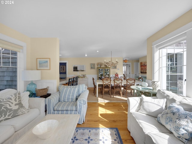 living room with an inviting chandelier and light hardwood / wood-style flooring