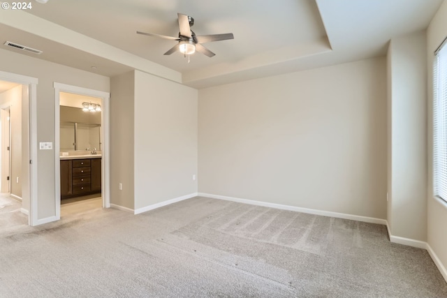 unfurnished bedroom with ceiling fan, light colored carpet, and connected bathroom