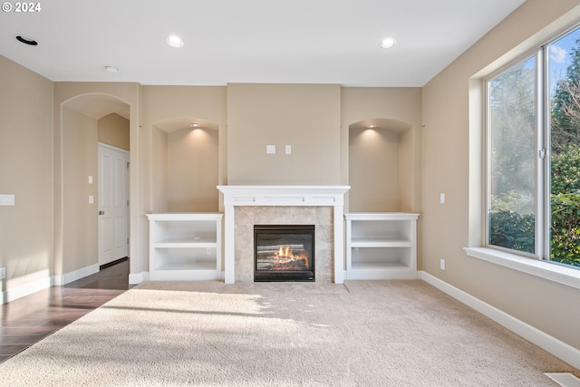 unfurnished living room featuring a fireplace and carpet flooring