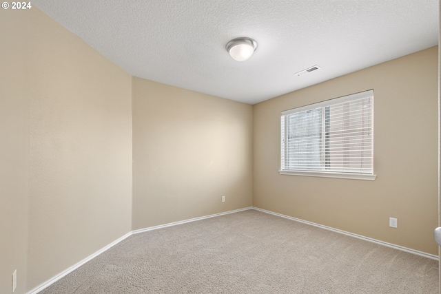 empty room featuring carpet and a textured ceiling