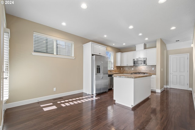 kitchen featuring white cabinets, decorative backsplash, a kitchen island, and stainless steel appliances