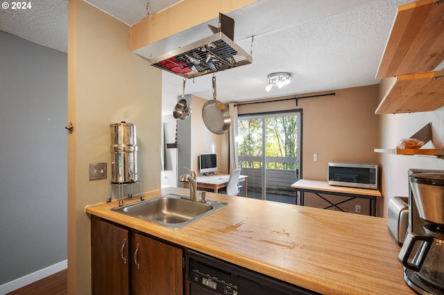 kitchen featuring black dishwasher, sink, dark wood-type flooring, and a textured ceiling