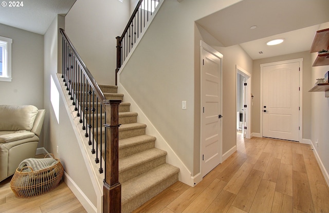 staircase with hardwood / wood-style floors