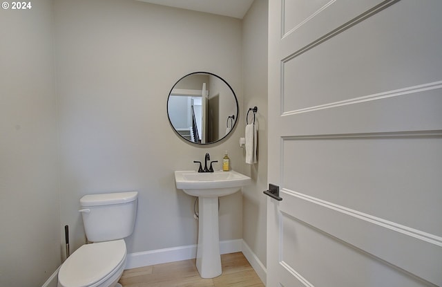 bathroom with hardwood / wood-style floors and toilet