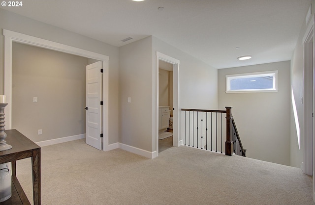 hallway featuring light carpet