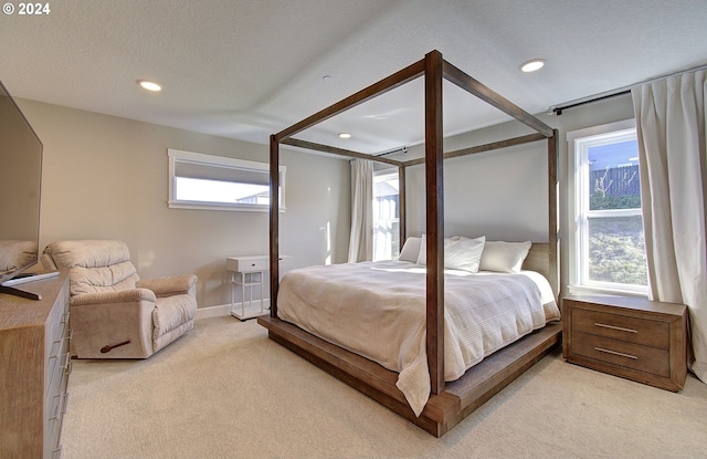 bedroom featuring light carpet and a textured ceiling